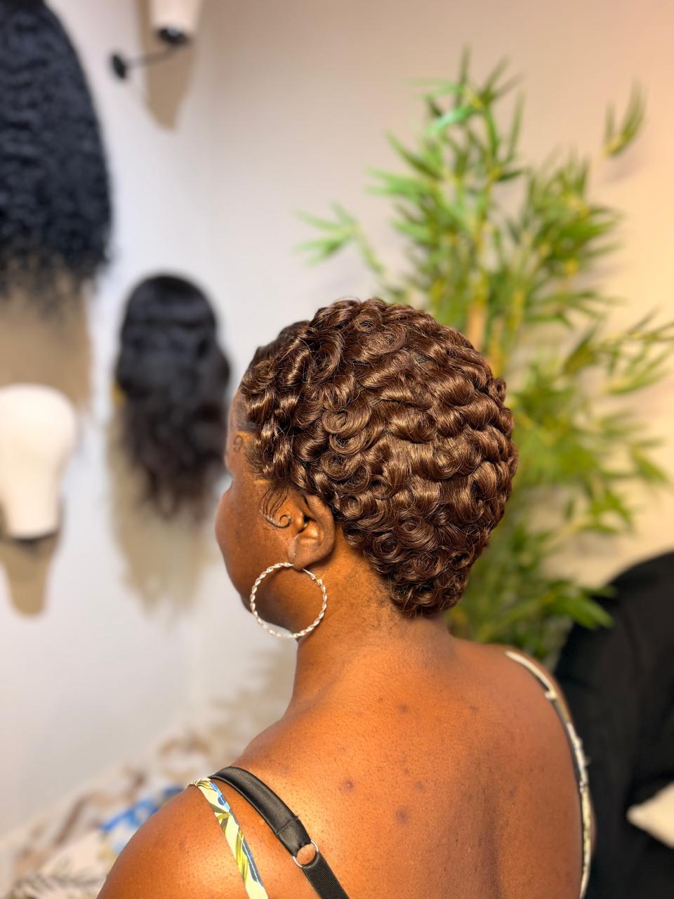 Client wearing a short copper-brown pixie installation with sculpted waves